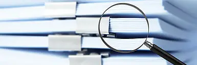 Dokumentenstapel & eine Lupe